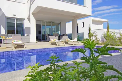 a villa with a swimming pool and a house at Villa Amelia in Paralimni