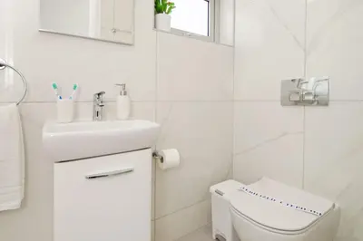 a white bathroom with a sink and a toilet at Villa Amelia in Paralimni