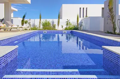 a swimming pool with blue tiles in a house at Villa Amelia in Paralimni