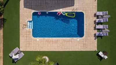 an overhead view of a swimming pool with loungers and a pool at Dene Hollow Oroklini in Voroklini