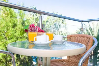 a table with two cups and two glasses of orange juice at Lucile - Coralli Beachfront Apartment in Paralimni