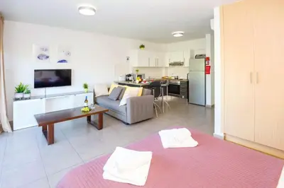 a large living room with a couch and a table at Lucile - Coralli Beachfront Apartment in Paralimni