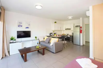 a living room with a couch and a table at Lucile - Coralli Beachfront Apartment in Paralimni