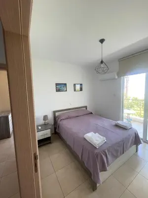 a bedroom with a bed with purple sheets and a window at Mythical Sands Resort - Maria in Protaras