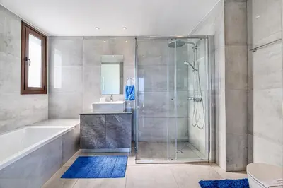 a bathroom with a shower and a tub and a sink at Serenity Seafront Villa in Ayia Napa