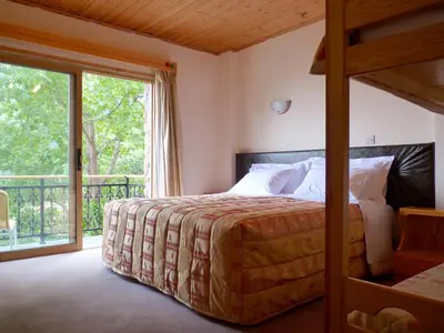 a bedroom with a bed and a large window at Mountain Rose Hotel & Restaurant in Pedoulas