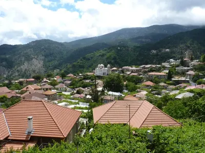 a view of a town with mountains in the background at Mountain Rose Hotel & Restaurant in Pedoulas