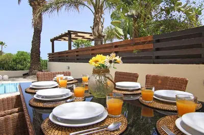 a table with plates and glasses of orange juice at Villa Oceania - Beachfront in Paralimni