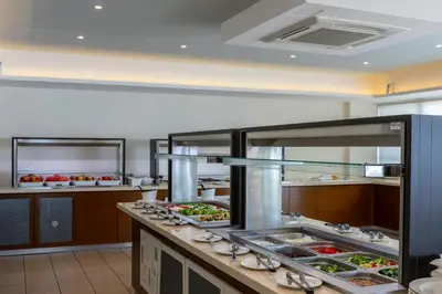 a large kitchen with many trays of food at Tofinis Hotel in Ayia Napa