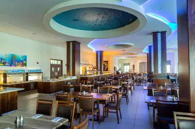 a dining room with wooden tables and chairs at Tofinis Hotel in Ayia Napa