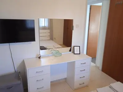 a white desk with a tv and a mirror at Larnaca, Pervolia 1 bedroom seaside apartment in Pervolia