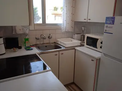 a small kitchen with a sink and a microwave at Larnaca, Pervolia 1 bedroom seaside apartment in Pervolia