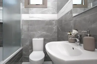 a bathroom with a white toilet and a sink at Villa Apollonia in Paralimni