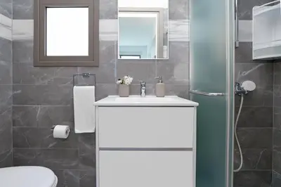 a bathroom with a sink and a toilet and a mirror at Villa Apollonia in Paralimni