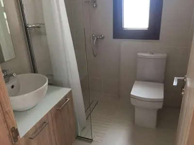 a bathroom with a toilet and a sink and a window at Modern 2 bedroom Beach Apartment in Limassol