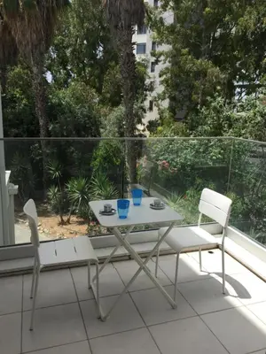 a table and two chairs sitting on a balcony at Modern 2 bedroom Beach Apartment in Limassol