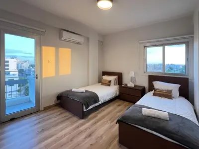a bedroom with two beds and a large window at River View Apartment in center Nicosia in Nicosia