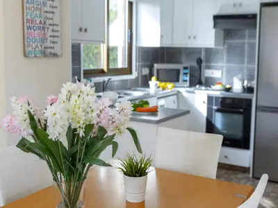 a kitchen with a vase of flowers on a table at Protaras Fig Tree Bay Villa Buena in Protaras