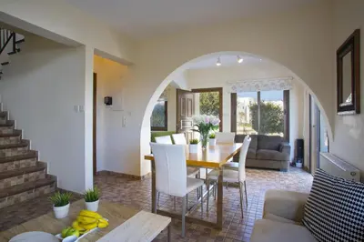 a dining room and living room with a table and chairs at Protaras Fig Tree Bay Villa Buena in Protaras