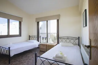 two beds in a room with two windows at Protaras Fig Tree Bay Villa Buena in Protaras