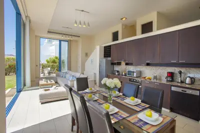 a kitchen and dining room with a table and chairs at Protaras Seafront Villa Infinte Aretousa in Protaras