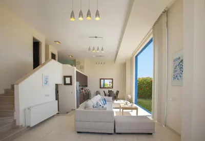 a living room with a couch and a table at Protaras Seafront Villa Infinte Aretousa in Protaras