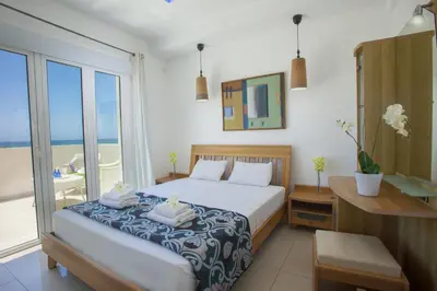 a bedroom with a bed and a desk and a window at Ayia Thekla Seafront Villa Lavender in Ayia Napa