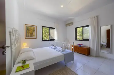 a white bedroom with a bed and a bathroom at Ayia Napa Ammos Sea View Villa in Ayia Napa