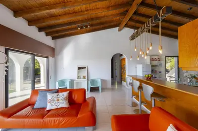 a living room with an orange couch and a kitchen at Ayia Napa Ammos Sea View Villa in Ayia Napa