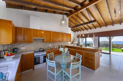 a kitchen with a table and chairs in a kitchen at Ayia Napa Ammos Sea View Villa in Ayia Napa