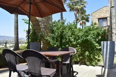 a table with chairs and an umbrella on a patio at George Houses in Pendakomo