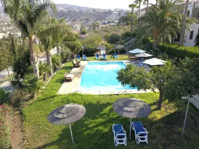 an image of a swimming pool with umbrellas at George Houses in Pendakomo