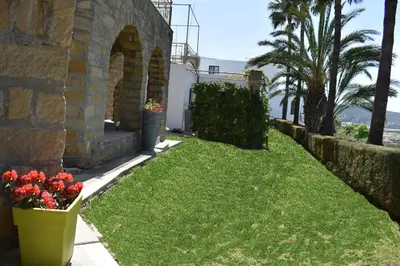 a yard with grass and flowers next to a building at George Houses in Pendakomo