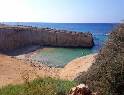 a beach with a pool of water next to the ocean at Ayia Napa Sun Central in Ayia Napa