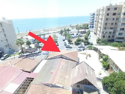 a red arrow on top of a building next to a beach at ZORBAS Sea View No 5 in Larnaka