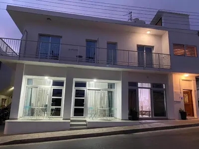 a white house with a balcony on top of it at ElleNapa Apts & Studios in Ayia Napa