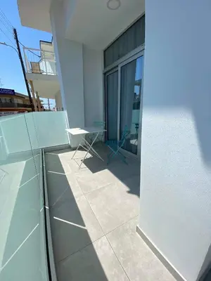 a balcony of a building with a glass wall at ElleNapa Apts & Studios in Ayia Napa