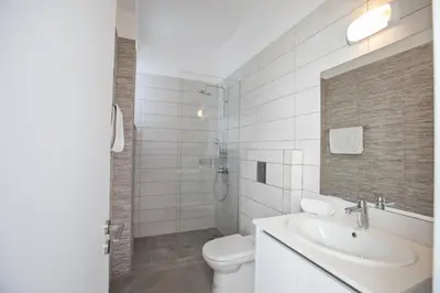 a white bathroom with a toilet and a sink at Villa Naya in Protaras