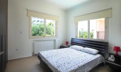 a bedroom with a bed and two windows at Protaras Villa Michelle 9 in Protaras