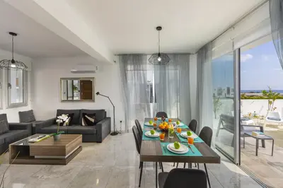 a living room with a table and a couch at Protaras Villa Alasia in Protaras