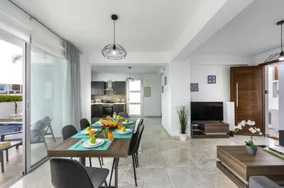 a dining room and living room with a table and chairs at Protaras Villa Alasia in Protaras