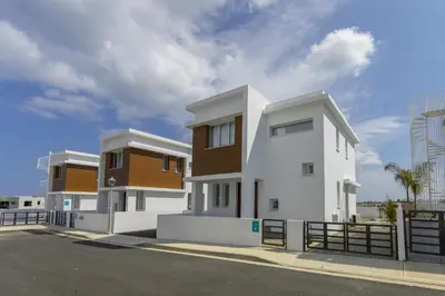 a white and brown building with a fence at Protaras Villa Alasia in Protaras
