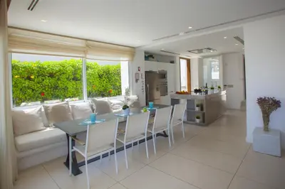 a living room with a couch and a table and chairs at Central Protaras Seaview Villa Zinnia in Protaras