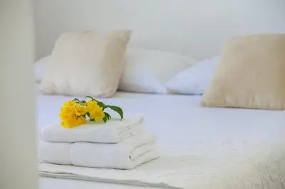 a pile of towels and flowers on a bed at Central Protaras Seaview Villa Zinnia in Protaras