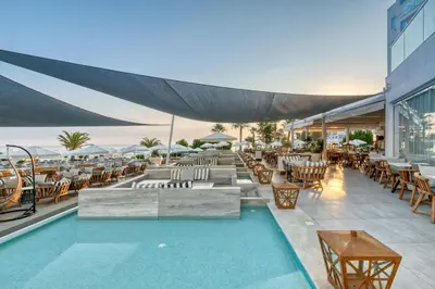 a resort with a pool and tables and chairs at King Jason Protaras - Designed for Adults by Louis Hotels in Protaras