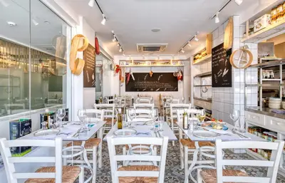a dining room with white tables and white chairs at King Jason Protaras - Designed for Adults by Louis Hotels in Protaras
