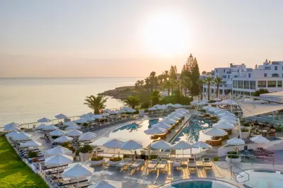 an aerial view of a resort with a pool and umbrellas at King Jason Protaras - Designed for Adults by Louis Hotels in Protaras