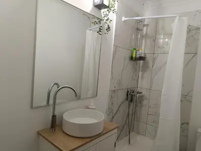 a white bathroom with a sink and a shower at Beach apartment's in Limassol