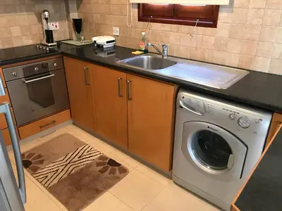 a kitchen with a washing machine and a sink at Apokryfo, one bedroom apartment close to the beach in Pissouri