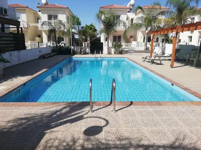 a swimming pool in front of a building at SUNNY HOME in Protaras